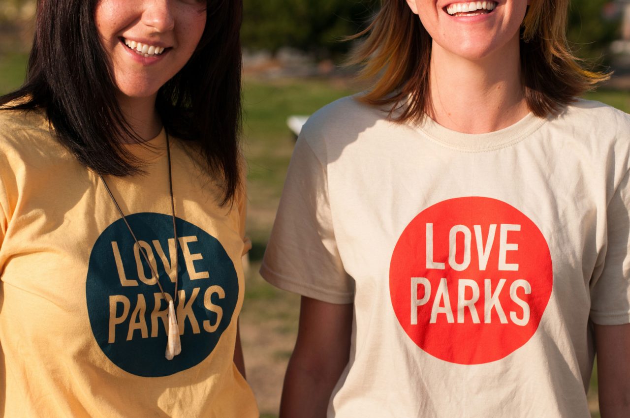 Two people show off Love Parks t-shirts.
