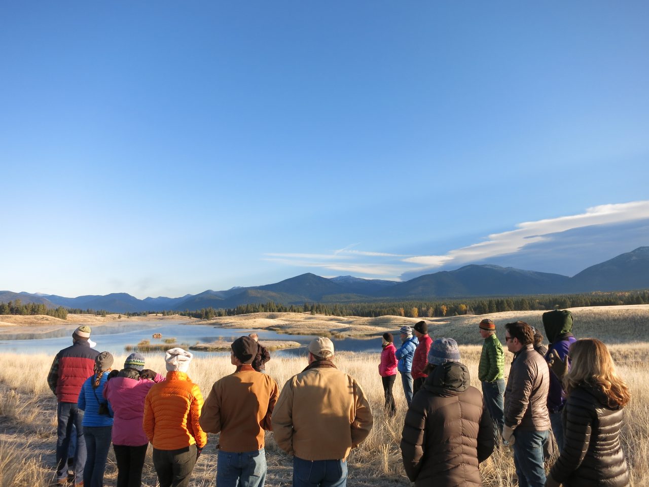 Photo of a group of people looking out at a mountain range.