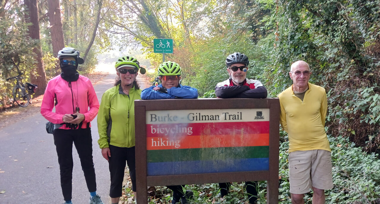 Fix the Burke-Gilman supporters stand near a trail sign.